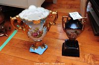 Both urn vases side by side on wood floor