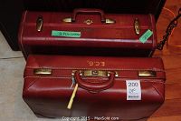 Top view of two stacked vintage leather suitcases, one Samsonite in brown color with brass hardware.