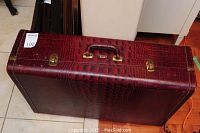 Full view of the vintage suitcase showing burgundy faux alligator texture and brass latches.