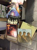 Front view of several open boxes showing assorted LP sleeves, including KISS 'Love Gun' and Toronto debut album.