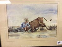 Close up photo of the watercolour painting depicting cowboy wrestling a steer, showing details of the art and signature.
