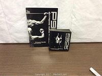 P90X fitness guide and stack of 12 DVDs