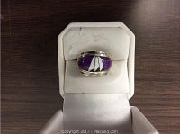Front view of the handcrafted sterling silver Navajo ring showing purple stone inlay inside the ring box.