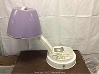 Full view of the vintage lavender travelling hairdryer with dome-shaped hood, adjustable arm, and white base.