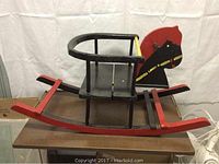 Side view of the vintage wooden rocking horse showing the curved rockers and safety seat rail