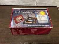 Box showing product packaging labeled '7 inch Digital Photo Frame' with pictures of the frame featuring three different interchangeable borders.
