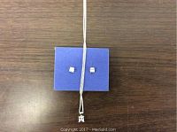 Sterling silver chain necklace and matching cubic zirconia stud earrings on a display card on wooden table.