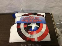 Folded white pajama top featuring the Captain America shield logo with packaging band marking it as a lounge set in size large.