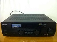 Front view of Kenwood VR-507 surround receiver showing control knobs, buttons, and input jacks.