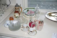 Photo of assorted glass bowls, cups, decorative items, and a Pyrex measuring cup.