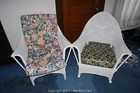 Two white wicker chairs with floral cushions together, showing both chairs side-by-side.