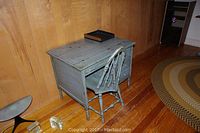 Full view of the vintage painted wooden desk with matching chair placed in front, both showing distressed paint in shabby chic style.