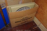 Window fan partially visible in original cardboard box labeled with model K-7 and General Electric branding.
