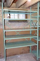 Full view of larger shelving unit with five shelves in basement setting