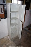 Full front open view of white metal cabinet showing four shelves inside and the cabinet height and depth.