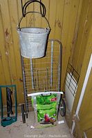 Folding metal grocery cart with galvanized bucket and bird feed bag