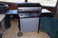 Full view of the Thermos propane grill showing size, wheels, side burner, and control panel.