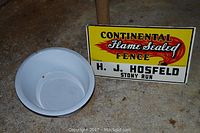 Photo of white enamel basin and Continental Flame Sealed Fence metal sign showing overall condition and details
