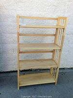 Front view of the bookcase showing four wooden shelves and slatted side panels.