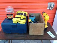 Full view of table with DeWalt drill, drill sharpener, vices, wooden box and drill bit set
