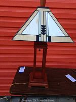 Front view of the 28-inch lamp with wooden base and plastic shade with geometric design