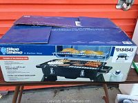 Photo of original boxed Blue Rhino portable LP gas barbecue grill with product image and branding visible