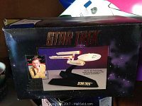 Box image of Star Trek U.S.S. Enterprise lighted figurine showing product name and images of the ship and William Shatner.