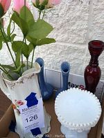 Photo showing a vintage Sterling China floral pitcher containing faux roses, two blue drip pottery vases, a red glass candle holder, and a milk glass footed candy dish.