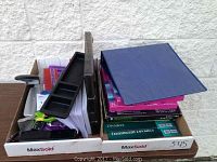 Wide view of the box with multiple office supplies including binder, photo paper, punches, stapler, scissors and organizing materials