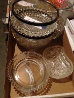 Beaded segmented dish with partition and two cut glass dishes, one with a black rim, arranged in a cardboard box