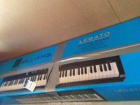 Williams Legato digital piano boxed with blue branding and product name visible on top and side.