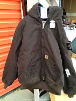 Full front view of the brown Carhartt hooded jacket showing zipper, hood, and ribbed cuffs and waistband.