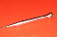 Side view of vintage Wahl-Ever gold filled mechanical pencil on orange background showing tapered gold filled body and fine lead tip.
