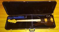 Full view of the Hondo 2 electric guitar in its hard lined case showing guitar body, neck, and strap.