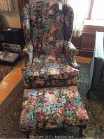 Front view of floral wingback chair and matching ottoman set.