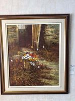Full view of framed oil painting showing rustic pathway, wooden door, and colorful flowers in wooden bucket.