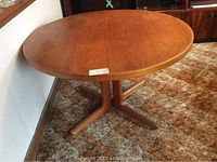 Round table top on splayed pedestal base