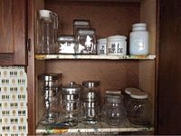 Shelves with various glass canisters and ceramic jars for kitchen storage