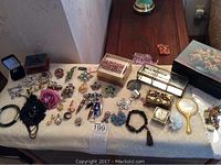 Overview of lot on table showing brooches, boxes and accessories