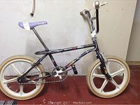 Side view of Leader Fly Team BMX bike with black LE411 Dominator frame, white mag wheels, and purple seat.