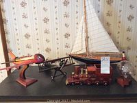 Front view of the set showing red airplane, biplane, sailboat, train, and lamp