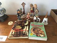 Main group photo showing all figurines and two collector’s guides on table.