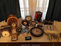 Lot of 16 clocks on dresser with different styles and brands visible