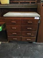 Front view of the 8-drawer wooden cabinet showing all drawers, wood handles, and caster wheels.