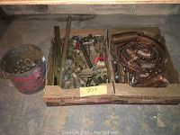 Overall view showing cardboard boxes and a bucket containing copper and brass pipe fittings