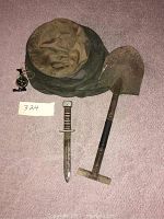 Overview photo showing the trench tool, trench knife, compass, and beekeeper hat on carpeted floor.