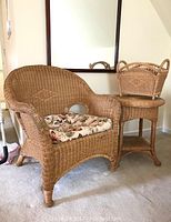 Front view of wicker chair with floral cushion, side table, and magazine rack
