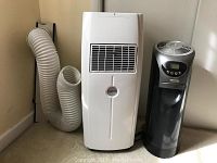 White Amcor portable air conditioner with vent hose next to black and silver Bionaire air filter tower.
