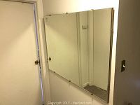 Front view of rectangular 48x36 plate glass mirror with beveled edges mounted on wall.