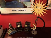 Overview photo showing all four items together on a table in front of a red wall and art poster.